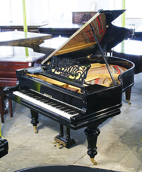 Restored, Berdux grand piano with a polished, black case and turned legs. Music desk features an Art Nouveau cut-out design with sinuous tendrils and the Berdux name
