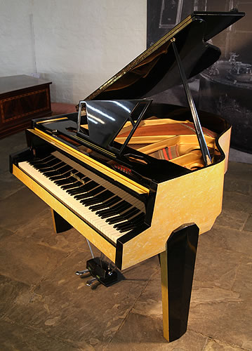 Reconditioned, 1950's Zimmermann baby grand piano for sale with a contrasting yellow and black formica case. Cabinet features an asymmetrical music desk with geometric cut-outs. The minimal tubular steel piano lyre is reminiscent of a sputnik satellite.