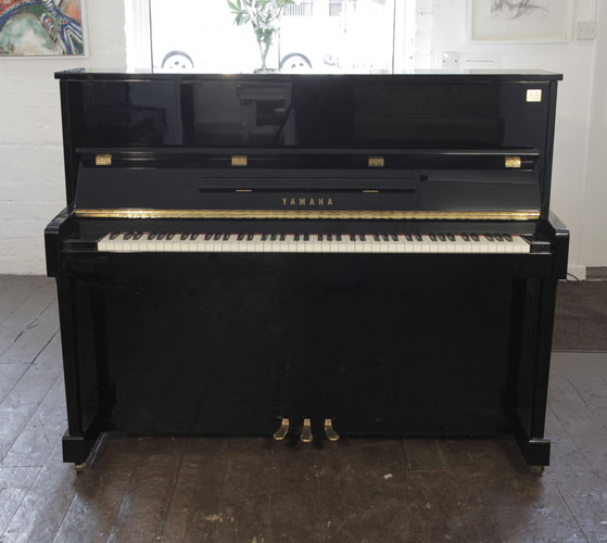  Yamaha ET121 upright piano for sale with a black case and brass fittings. Piano has an eighty-eight note keyboard and three pedals.