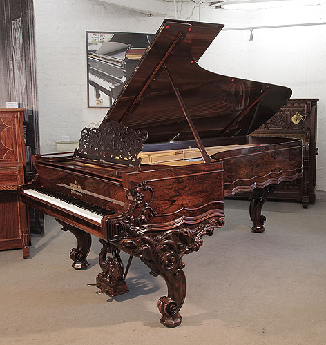 An 1874, Steinway & Sons Model D concert grand piano for sale with a rosewood case, filigree music desk and ornately carved, reverse scroll legs. Piano has an eighty-eight note keyboard and a two-pedal lyre. 