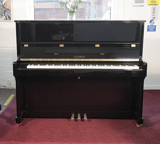 Brand new Feurich Model 122 upright piano with a black case and chrome fittings.  Piano has an eighty-eight note keyboard and three pedals.