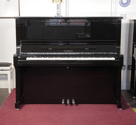 Brand new, Feurich Model 133 Concert upright piano with a black case and chrome fittings. Cabinet features and extendable LED strip light and a slow fall mechanism. Piano has an eighty-eight note keyboard and three pedals