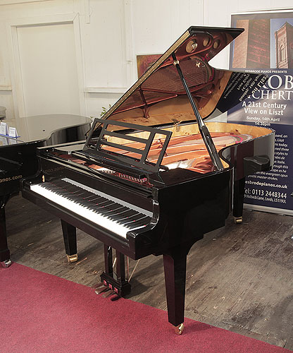 Brand new, Feurich model 218 concert I grand piano with a black case and brass fittings. Piano features a rectangular openwork music desk with LED strip lighting.  Piano has an eighty-eight note keyboard and a three-pedal piano lyre. 