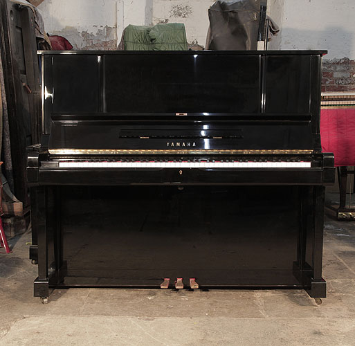 Reconditioned, 1982, Yamaha YUX upright piano for sale with a black case and brass fittings. Piano has an eighty-eight note keyboard and three pedals. 