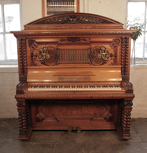Piano for sale. German Late Renaissance style, 1896, Pfaffe upright piano for sale with a walnut case and burr walnut panels. Cabinet features a front openwork panel of turned spindles that acts as a sound box. Piano has a mock roll top piano fall.  Piano has twelve barley twist legs. Piano has an eighty-five note keyboard and two pedals