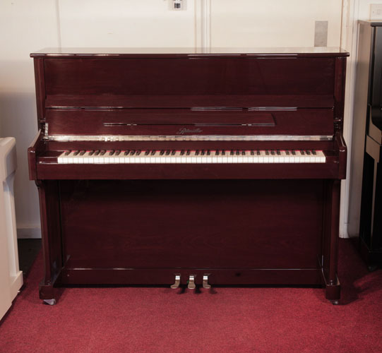 A 2016, Ritmuller upright piano for sale with a mahogany case and slow fall mechanism. Condition as new. Piano has an eighty-eight note keyboard and and three pedals