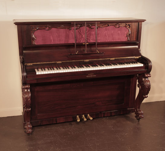Reconditioned, Victorian upright piano with a rosewood case and carved, cabriole legs. Piano has an eighty-eight note keyboard and three pedals. 