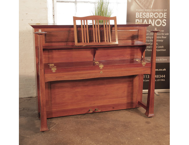 Arts and Crafts style, 1899, Bechstein model IV upright piano with a walnut case. Cabinet features sizeable, brass hinges. The large sculptural legs taper to candlesticks. Design by Walter Cave.