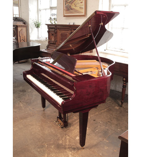 A 1990, Hyundai G-50A baby grand piano with a cherry mahogany case and square, tapered legs. Piano has an eighty-eight note keyboard and a three-pedal lyre.