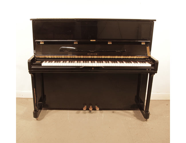 Reconditioned, 1996, Samick SU121SP upright piano with a black case and polyester finish. Piano has an eighty-eight note keyboard and three pedals. 