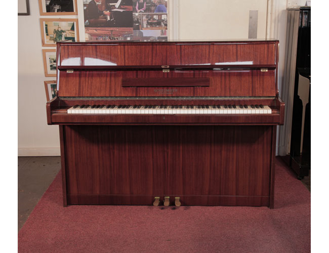 Reconditioned, 1972, Schiedmayer upright piano with a mahogany case and polyester finish. Piano has an eighty-eight note keyboard and three pedals . 