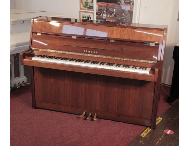 Reconditioned, 1987, Yamaha M108N  with a walnut gloss case and brass fittings. Piano has an eighty-eight note keyboard and three pedals. 