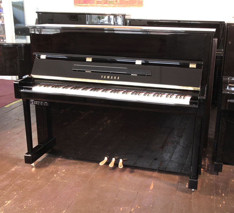 A 2020, Yamaha b3e PE-Silent upright piano with a black case and fitted Yamaha Silent System. Piano has an eighty-eight note keyboard and three pedals.  