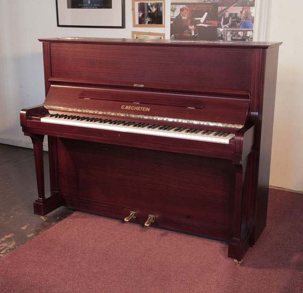 Reconditioned, 1986, Bechstein  model 11  upright piano with a satin, mahogany case and brass fittings. Piano has an eighty-eight note keyboard and two pedals. 