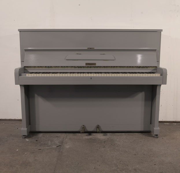 A 1953, Broadwood upright piano with a grey gloss cabinet and brass fittings. Piano has an eighty-eight note keyboard and two pedals