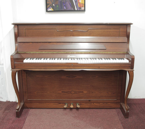 Dietmann upright piano with a walnut case and cabriole legs. Piano has an eighty-eight note keyboard  and three pedals 