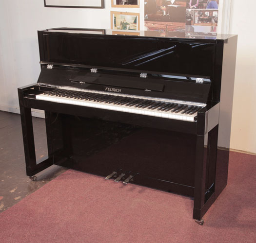 Reconditioned, 2013, Feurich Model 115 upright piano with a black case and chrome fittings. Piano has an eighty-eight note keyboard and  three pedals