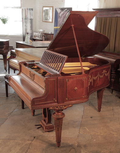 A 1901, Schiedmayer grand piano for sale with a quarter cut mahogany case. Entire cabinet features ormolu mounts of beading, swags, bows and festoons. Piano has an eighty-five note keyboard and a two-pedal lyre.