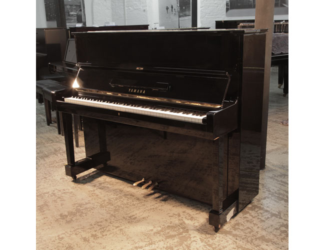 Reconditioned, 1970s, Yamaha U1 upright piano with a black case and polyester finish. Piano has an eighty-eight note keyboard and three pedals.