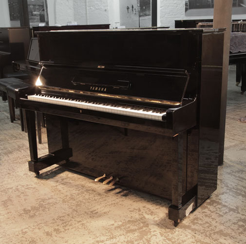  Reconditioned, 1970's, Yamaha U1 upright piano with a black case and polyester finish. Piano has an eighty-eight note keyboard and three pedals. 
