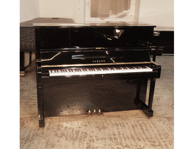 Reconditioned, 1975, Yamaha U1 upright piano in black gloss with brass fittings. Piano has an eighty-eight note keyboard and three pedals