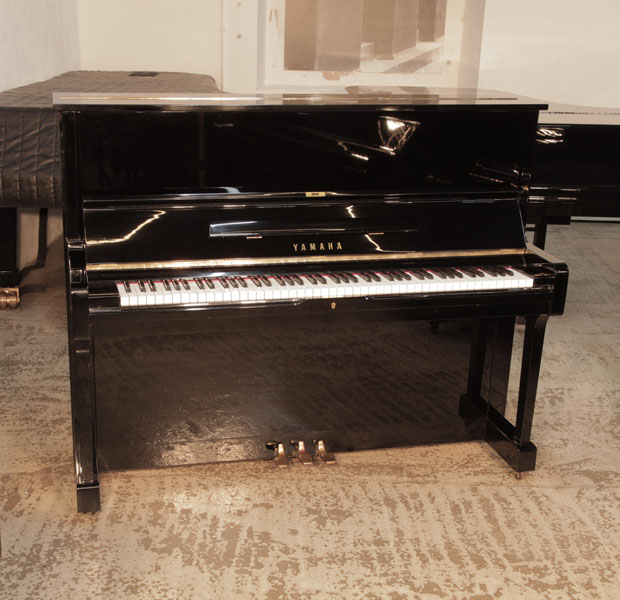Reconditioned, 1975, Yamaha U1 upright piano for sale with a black case and brass fittings. Piano has an eighty-eight note keyboard and three pedals.  