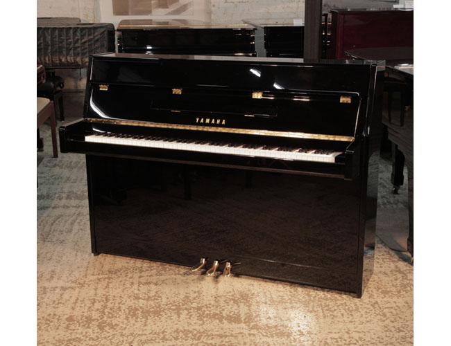 Pre-owned, Yamaha bl PE upright piano with a gloss black case and brass fittings.