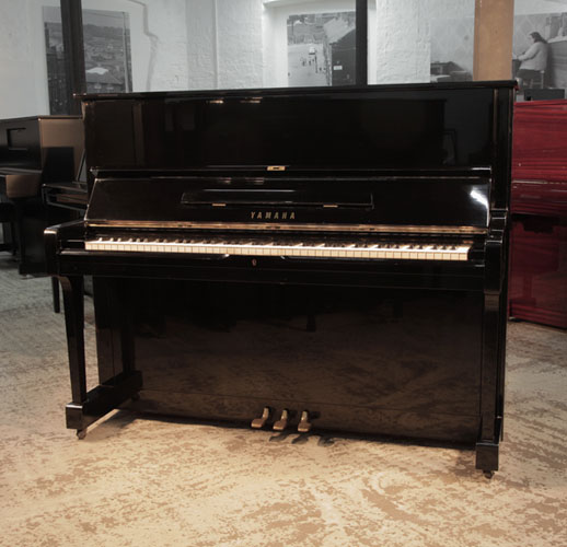  Reconditioned, 1973, Yamaha U1 upright piano with a black case and polyester finish. Piano has an eighty-eight note keyboard and three pedals. 